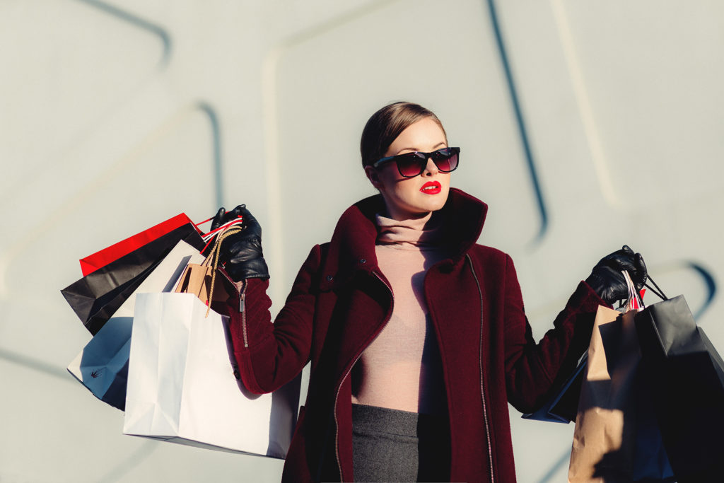 Shopper carrying branded paper shopping bags